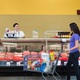 Butcher serving customers at meat counter of grocery store